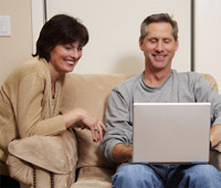 forties couple usinf laptop computer